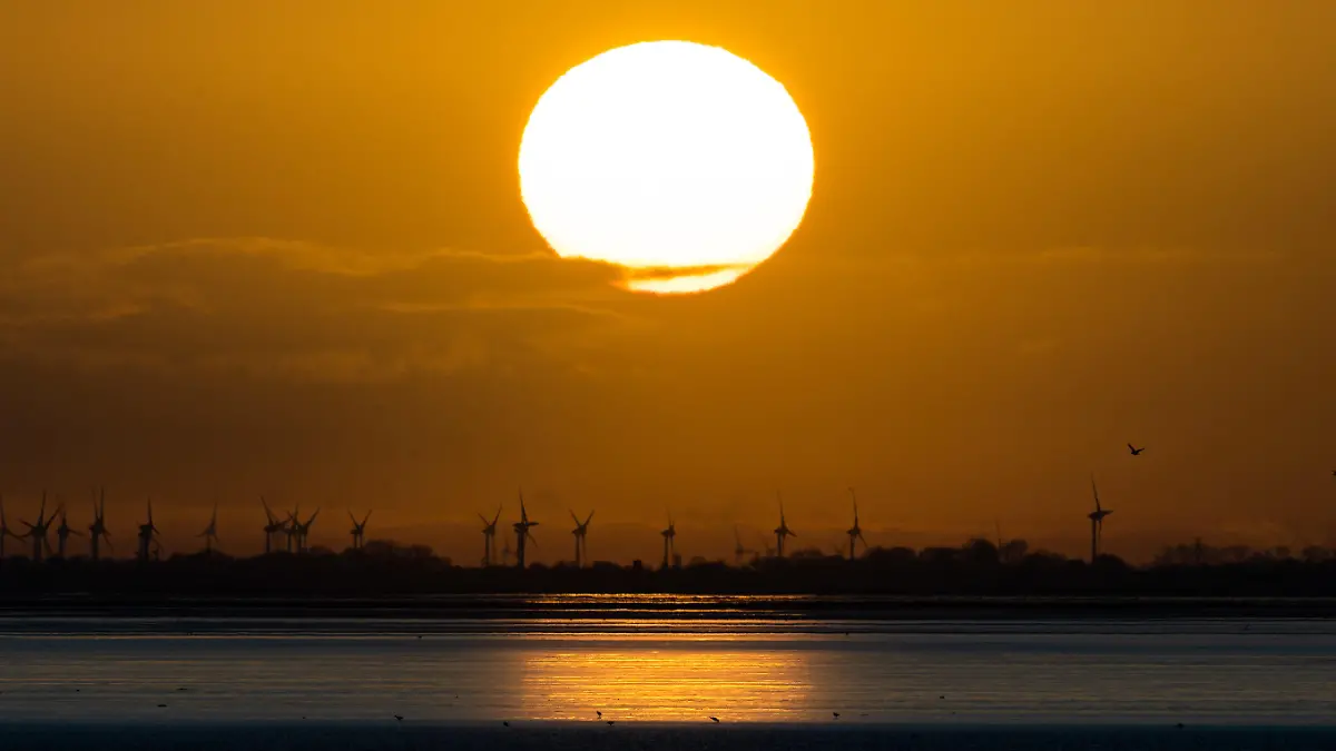 27.02.2020, Niedersachsen, Norderney: Der Sonnenaufgang ist über dem Festland an der ostfriesischen Nordseeküste zu sehen. Fotografiert von der Insel Norderney aus. Foto: Mohssen Assanimoghaddam/dpa +++ dpa-Bildfunk +++