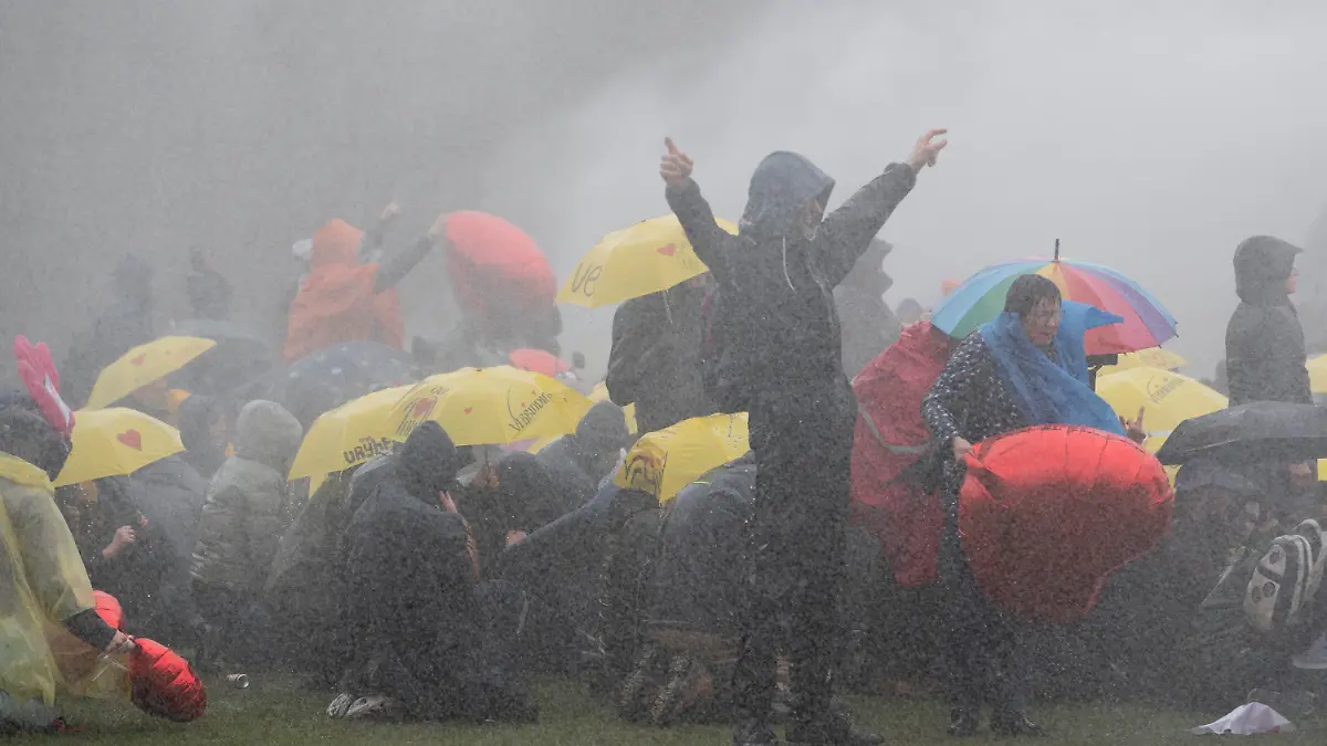 Dutch police uses a water cannon to break up a demonstration against coronavirus related government policies including the curfew and the tight lockdown in Amsterdam, Netherlands, Sunday, March 28, 2021. (AP Photo/Peter Dejong)