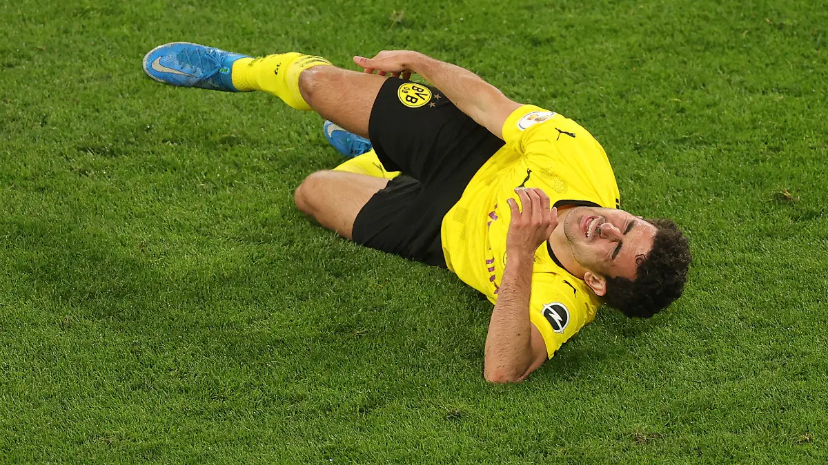 Dortmund's Mateu Morey grimaces in pain after an injury during the German Soccer Cup semifinal match between Borussia Dortmund and Holstein Kiel in Dortmund, Germany, Saturday, May 1, 2021. (Friedemann Vogel/Pool via AP)