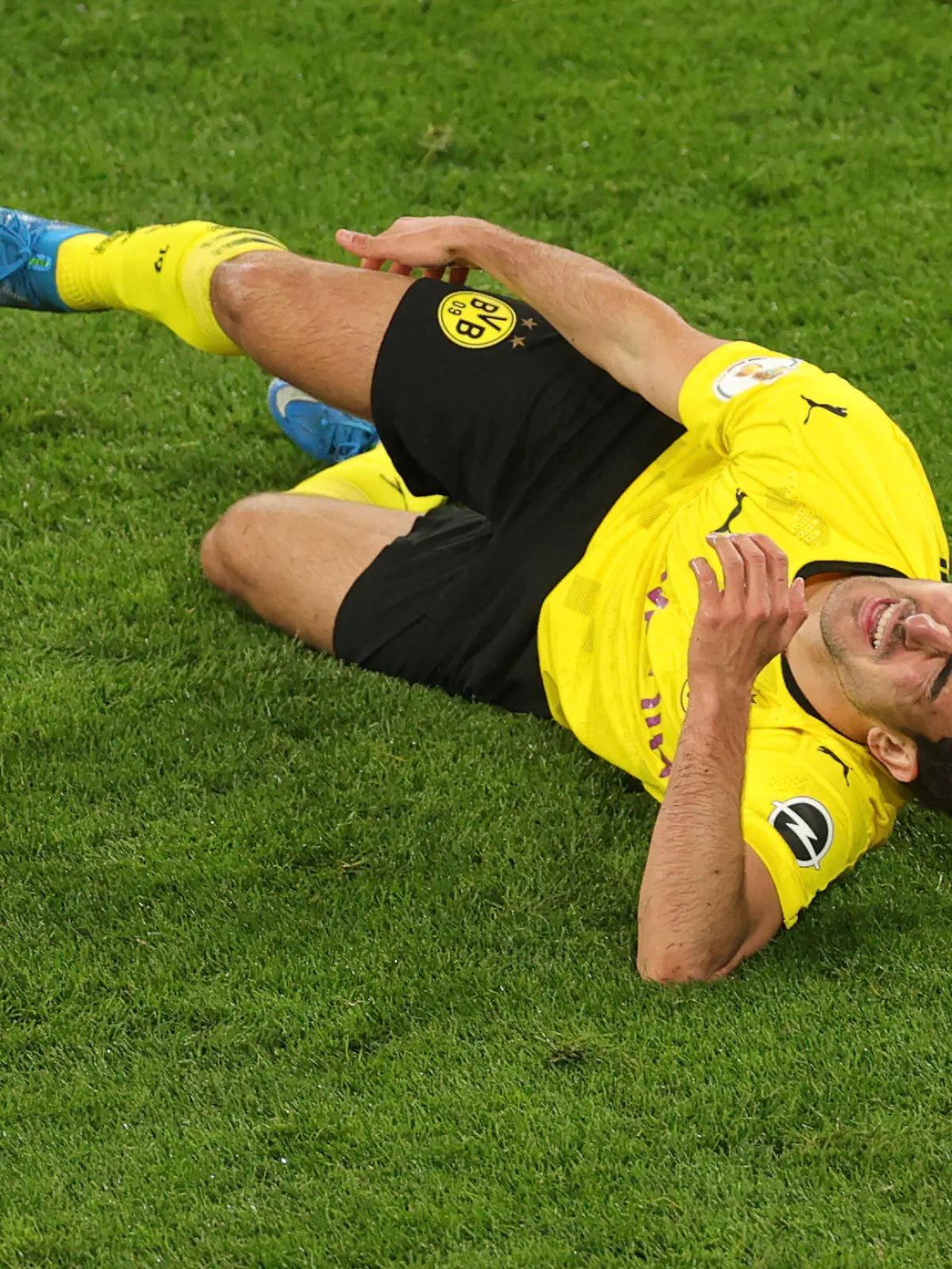 Dortmund's Mateu Morey grimaces in pain after an injury during the German Soccer Cup semifinal match between Borussia Dortmund and Holstein Kiel in Dortmund, Germany, Saturday, May 1, 2021. (Friedemann Vogel/Pool via AP)