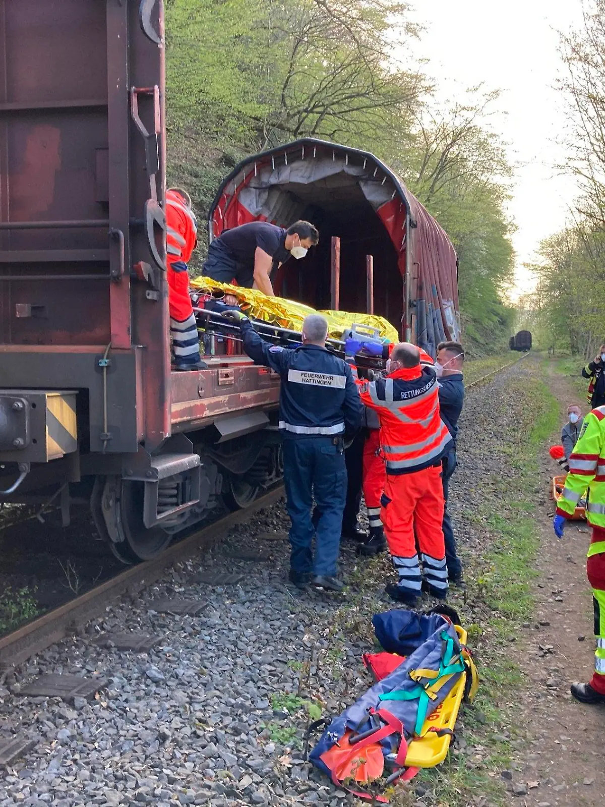 HANDOUT - 30.04.2021, Nordrhein-Westfalen, Hattingen: Feuerwehrleute retten eine Person nach einem Unfall. Zwei Jugendliche sind einen Steilhang hinuntergestürzt und dabei schwer verletzt worden. Foto: Jens Herkströter/Feuerwehr Hattingen/dpa - ACHTUNG: Nur zur redaktionellen Verwendung im Zusammenhang mit der aktuellen Berichterstattung und nur mit vollständiger Nennung des vorstehenden Credits +++ dpa-Bildfunk +++