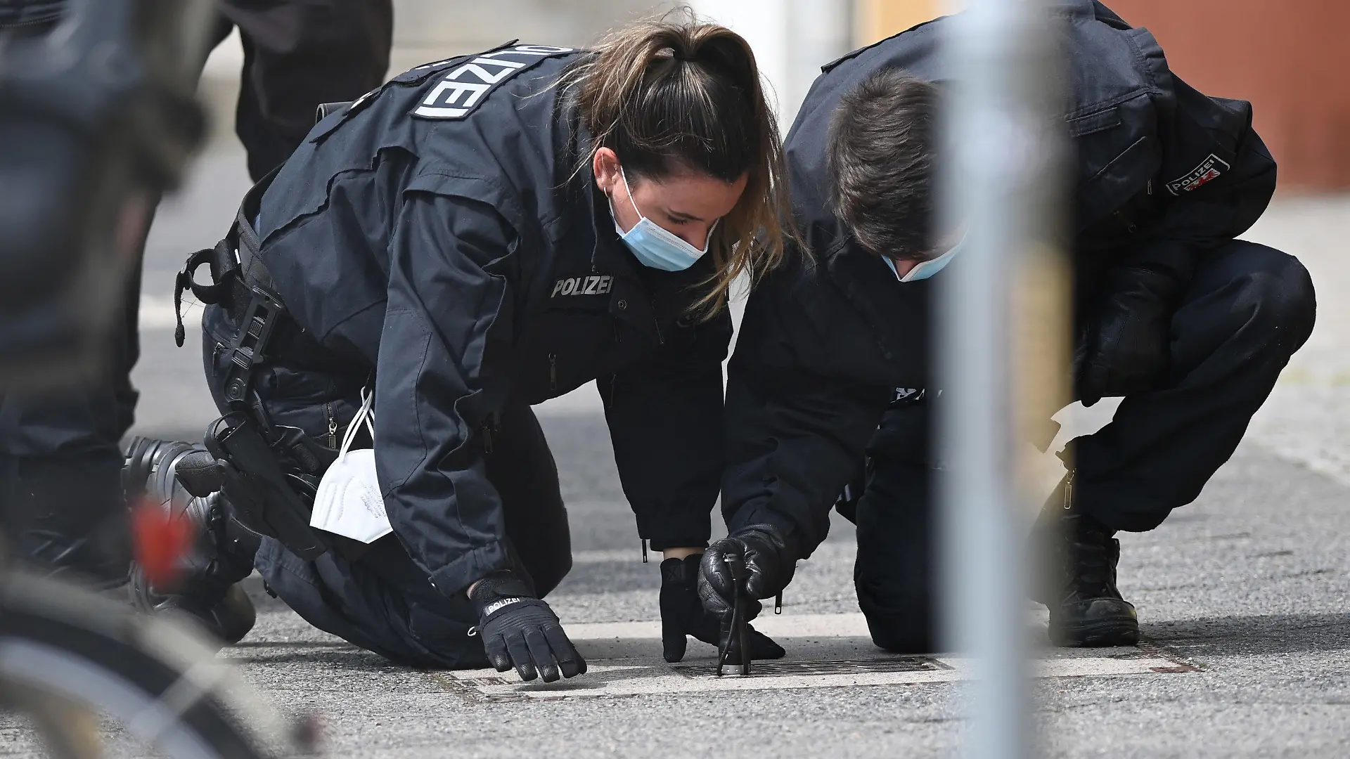 29.04.2021, Brandenburg, Potsdam: Polizisten suchen auf dem Fußweg und neben den Gebäuden des diakonischen Anbieters Oberlinhaus nach Spuren. In der Einrichtung mit einem Wohnheim waren am Vortag vier Leichen und eine schwer verletzte Person gefunden worden. Zum Oberlinhaus gehören neben Einrichtungen für Menschen mit Behinderung auch eine Schule und eine Orthopädische Klinik. Foto: Soeren Stache/dpa-Zentralbild/dpa +++ dpa-Bildfunk +++
