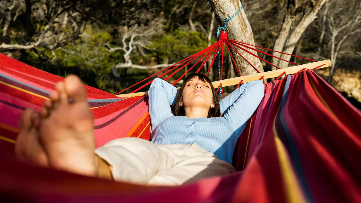 young woman caucasian sleeping in hammock Sant Elm, IB, Spain PUBLICATIONxINxGERxSUIxAUTxONLY CR_PESU210416-706701-01 ,model released, Symbolfoto