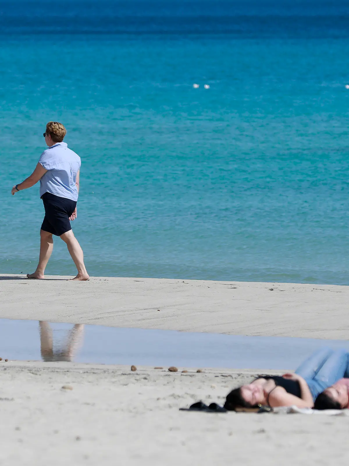 10.03.2023, Spanien, Son Servera: Eine Frau spaziert am Strand von Cala Millor auf Mallorca. Ungewöhnlich hohe Temperaturen für diese Jahreszeit werden für dieses Wochenende auf Mallorca erwartet. Foto: Clara Margais/dpa +++ dpa-Bildfunk +++