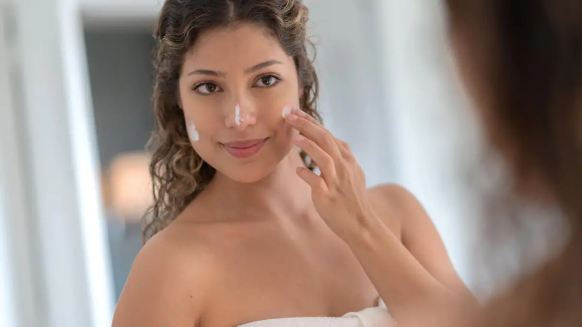 Frau trägt UV-Schutzcreme auf