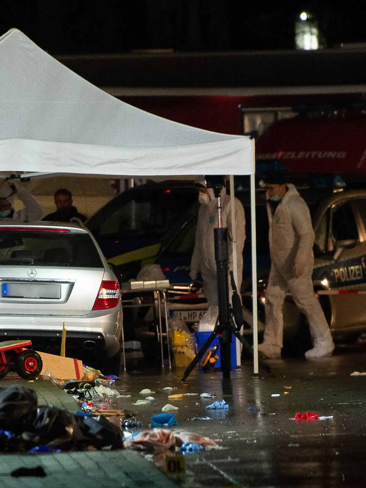 ARCHIV - 24.02.2020, Hessen, Volkmarsen: Ermittlungsbeamte stehen an einem Auto, das bei einem Rosenmontagszug in eine Menschenmenge gefahren war. Am 24. Februar 2020 war in der Stadt ein Auto in eine Zuschauermenge von einem Rosenmontagsumzug gefahren. Der damals 29 Jahre alte Fahrer soll den Wagen absichtlich in das Gedränge gesteuert haben. 90 Menschen erlitten teils schwere Verletzungen. Ab 3. Mai soll der  der Tatverdächtige vor Gericht stehen. (zu dpa: «Hoffnungen und Erwartungen vor Prozess um Auto-Attacke») Foto: Swen Pförtner/dpa - ACHTUNG: Autokennzeichen gepixelt +++ dpa-Bildfunk +++