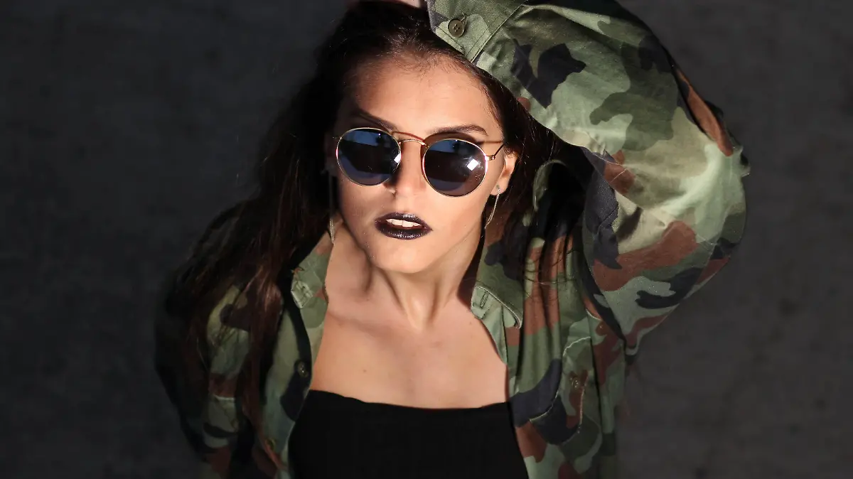 Frau mit Sonnenbrille trägt Camouflage als Statement.