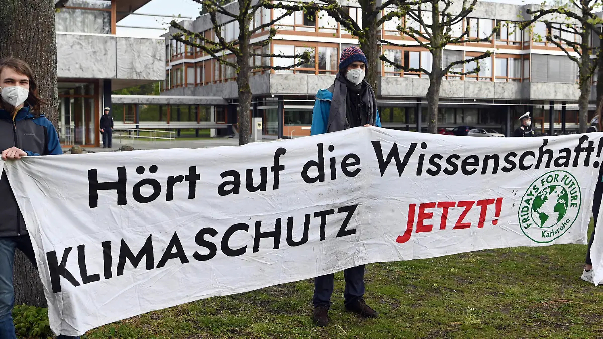29.04.2021, Baden-Württemberg, Karlsruhe: Mitglieder der Karlsruher Gruppe von Fridays for Future halten vor dem Bundesverfassungsgericht ein Transparent auf dem steht ·Hört auf die Wissenschaft! Klimaschutz jetzt!·. Das Gericht verkündete sein Urteil zum Klimaschutzgesetz. Laut dem Urteil reicht das Klimaschutzgesetz nicht weit genug. Die Richter verpflichteten den Gesetzgeber am Donnerstag, bis Ende kommenden Jahres die Reduktionsziele für Treibhausgasemissionen für die Zeit nach 2030 näher zu regeln. Foto: Uli Deck/dpa +++ dpa-Bildfunk +++