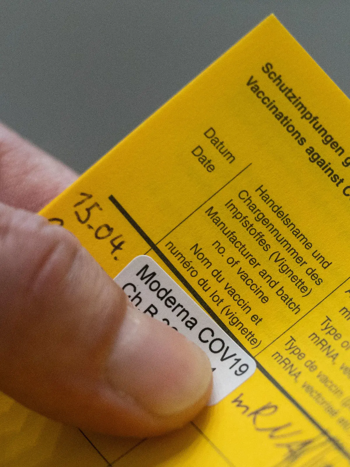 15.04.2021, Baden-Württemberg, Stuttgart: Ein Aufkleber der auf eine Impfung mit dem Impfstoff Moderna hinweist, klebt im Impfzentrums des Klinikum Stuttgart im Impfpass eines Impflings. Die baden-württembergische Landesregierung rechnet schon bald mit mehr Impfstoff und lädt Verbände und Vertreter des Gesundheitssystems zu einem Impfgipfel am 16. April. Foto: Marijan Murat/dpa +++ dpa-Bildfunk +++