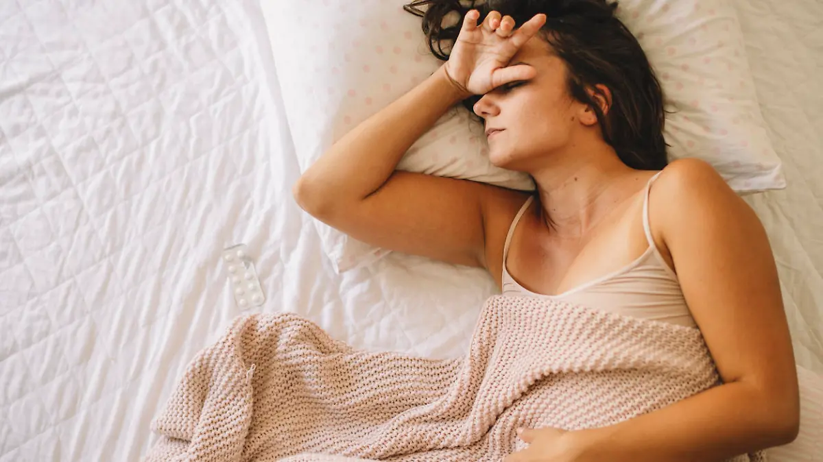 Frau liegt müde im Bett