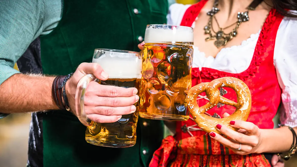 Mann und Frau in Tracht mit Bier und Brezel