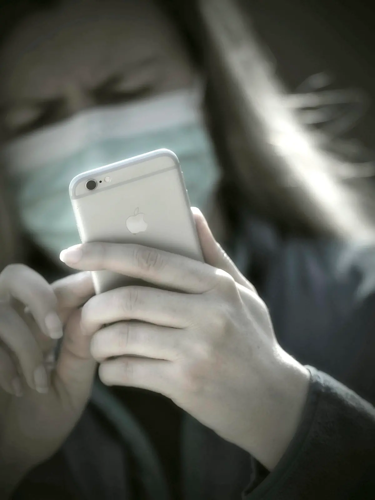  08.04.2020, Symbolbild, Corona-Krise, Frau schaut auf ihr Handy mit Gesichtsmaske. 08.04.2020, Corona-Krise Handy-Nutzung 08.04.2020, Corona-Krise Handy-Nutzung *** 08 04 2020, Symbol picture, Corona crisis, Woman looking at her mobile phone with face mask 08 04 2020, Corona crisis mobile phone use 08 04 2020, Corona crisis mobile phone use