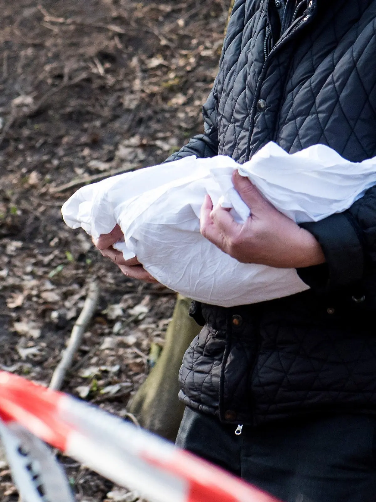 ARCHIV - 22.03.2019, Schleswig-Holstein, Glinde: Ein Bestatter trägt eine Babyleiche, die Schüler am Vormittag entdeckt haben, aus einem Waldstück. In Glinde startet eine DNA-Reihenuntersuchung im Fall des toten Babys. Die Ermittlungen zur Herkunft des Kindes wurden eingestellt. (Zu dpa «Herkunft des toten Babys von Glinde bleibt unbekannt») Foto: Daniel Bockwoldt/dpa +++ dpa-Bildfunk +++