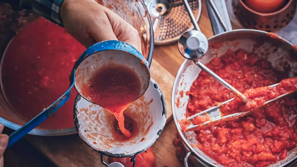 Tomaten mit der Hand zu passieren macht Arbeit und Schmutz