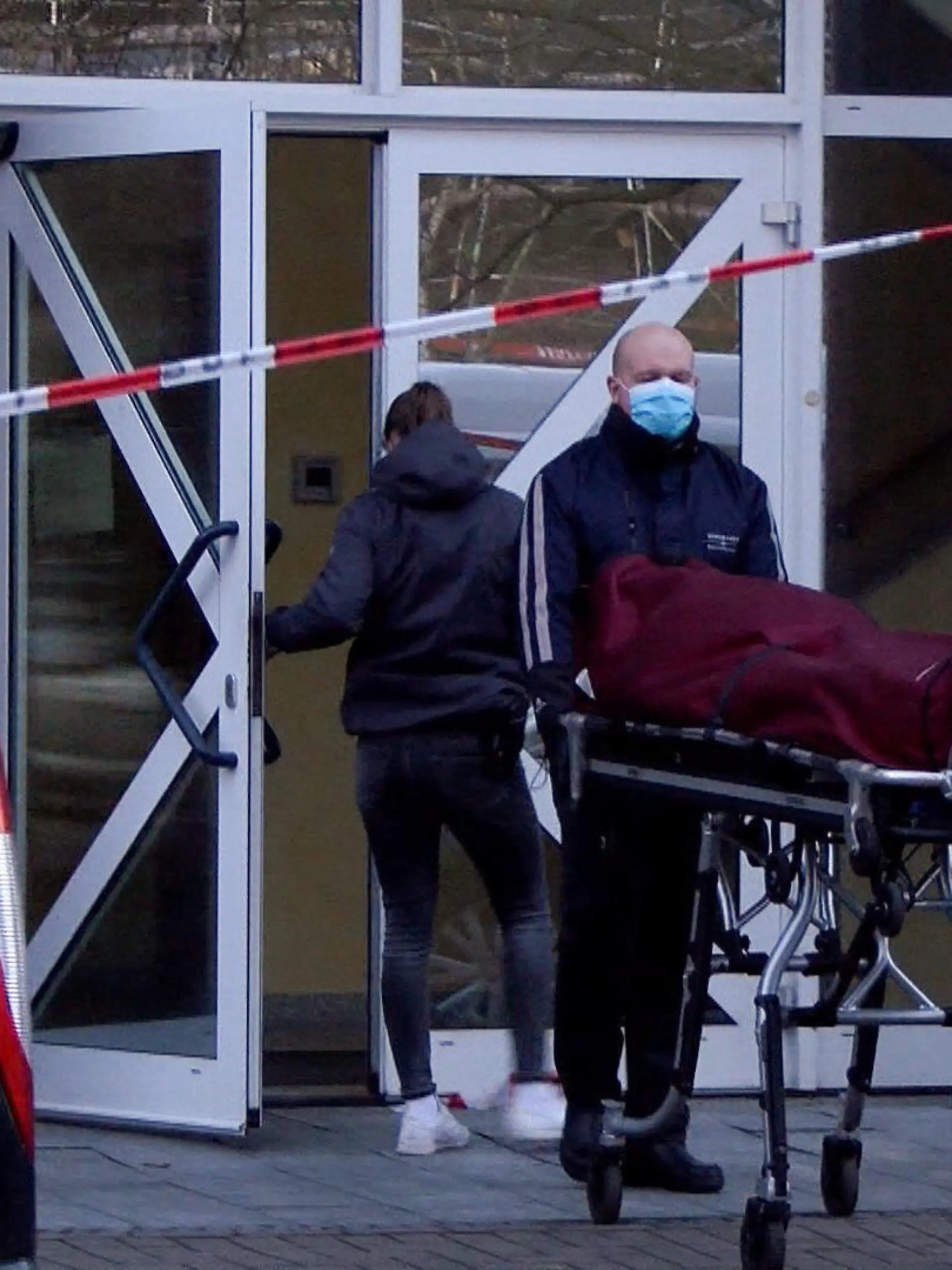 14.04.2021, Bremn: Bestatter bringen einen Leichnam zu ihrem Wagen nach einem Stromunfall mit tödlichem Ausgang. Ein 55-Jähriger hat in einem Bürogebäude einen tödlichen Stromschlag erlitten. In dem Gebäude mit Arztpraxen hatte am Mittwochnachmittag den Angaben zufolge aus bislang unbekannter Ursache eine Tür unter Strom gestanden. Ein herbeigerufener Feuerwehrmann erlitt ebenfalls einen Stromschlag und musste reanimiert werden, wie ein Sprecher der Feuerwehr am Mittwochabend sagte. Foto: Christian Butt/Kai Moorschlatt/Nord-West-Media /dpa +++ dpa-Bildfunk +++