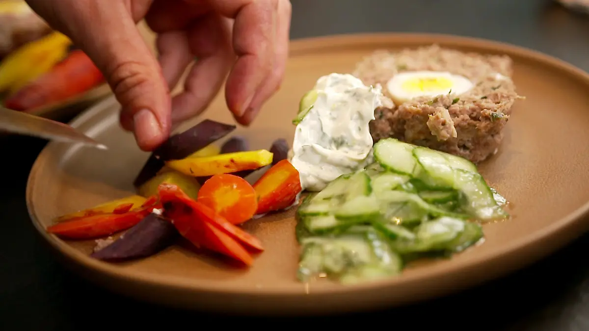 Gefüllter Hackbraten mit Gemüsebeilage und Gurkensalat.