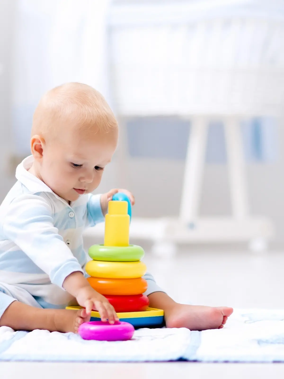 Babyentwicklung: Baby spielt mit bunten Ringen