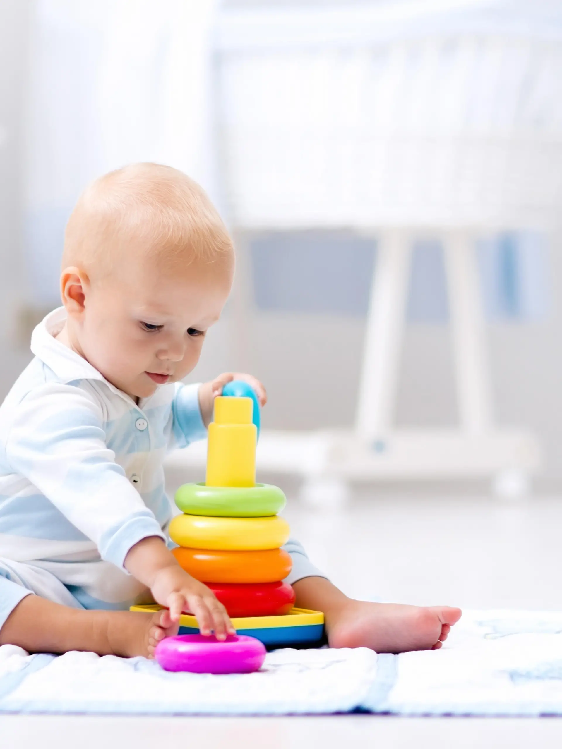 Babyentwicklung: Baby spielt mit bunten Ringen