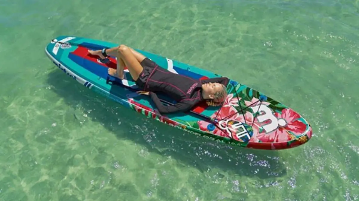 Frau liegt auf einem Stand Up Paddling Board im Wasser.