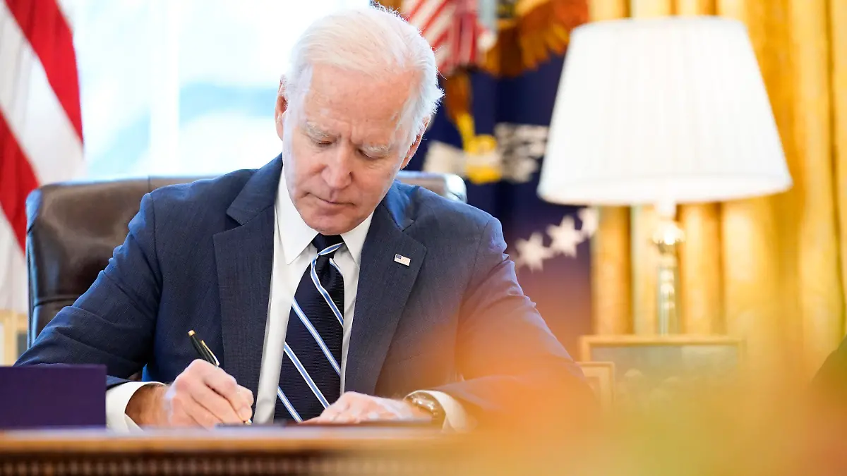 ARCHIV - 11.03.2021, USA, Washington: Joe Biden, Präsident der USA, setzt im Oval Office ein billionenschweres Corona-Konjunkturpaket mit seiner Unterschrift in Kraft. Foto: Andrew Harnik/AP/dpa +++ dpa-Bildfunk +++