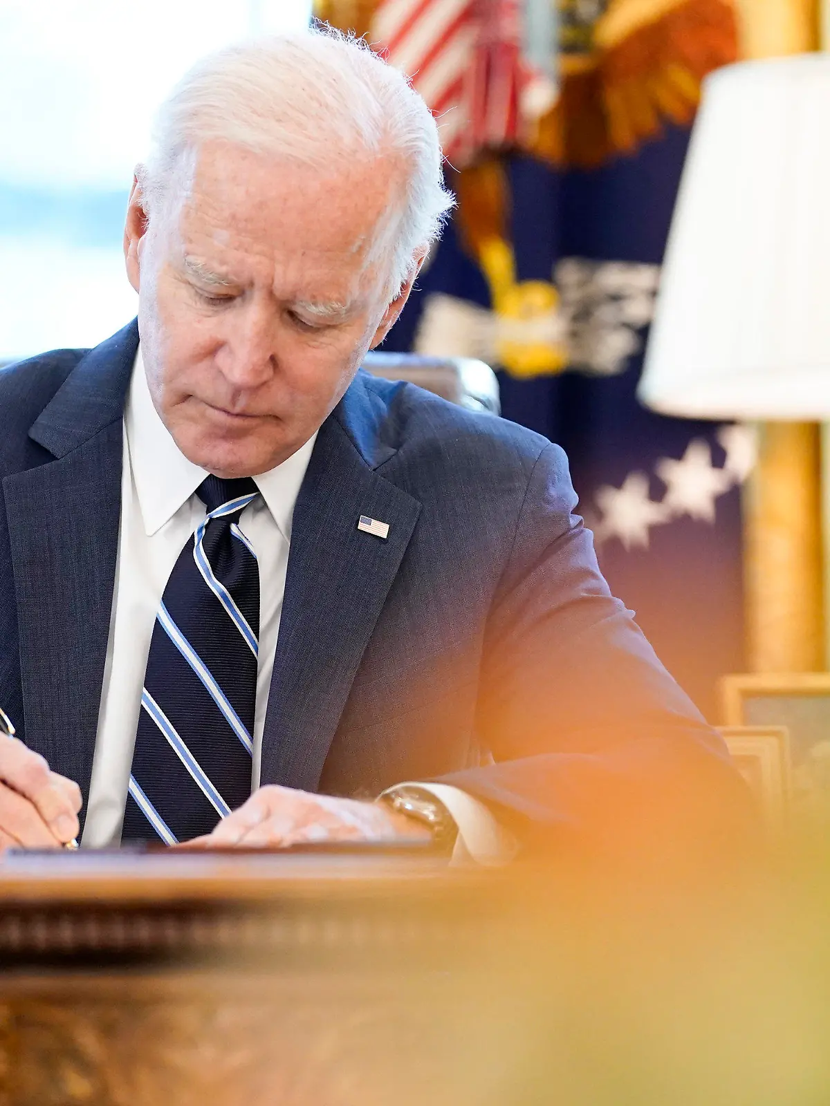 ARCHIV - 11.03.2021, USA, Washington: Joe Biden, Präsident der USA, setzt im Oval Office ein billionenschweres Corona-Konjunkturpaket mit seiner Unterschrift in Kraft. Foto: Andrew Harnik/AP/dpa +++ dpa-Bildfunk +++