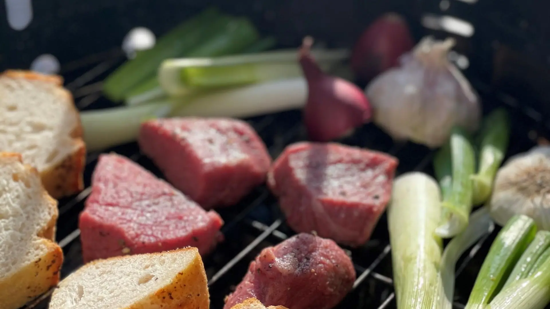 Grill mit Baguette, Steak, Lauch, Zwiebeln und Knoblauch