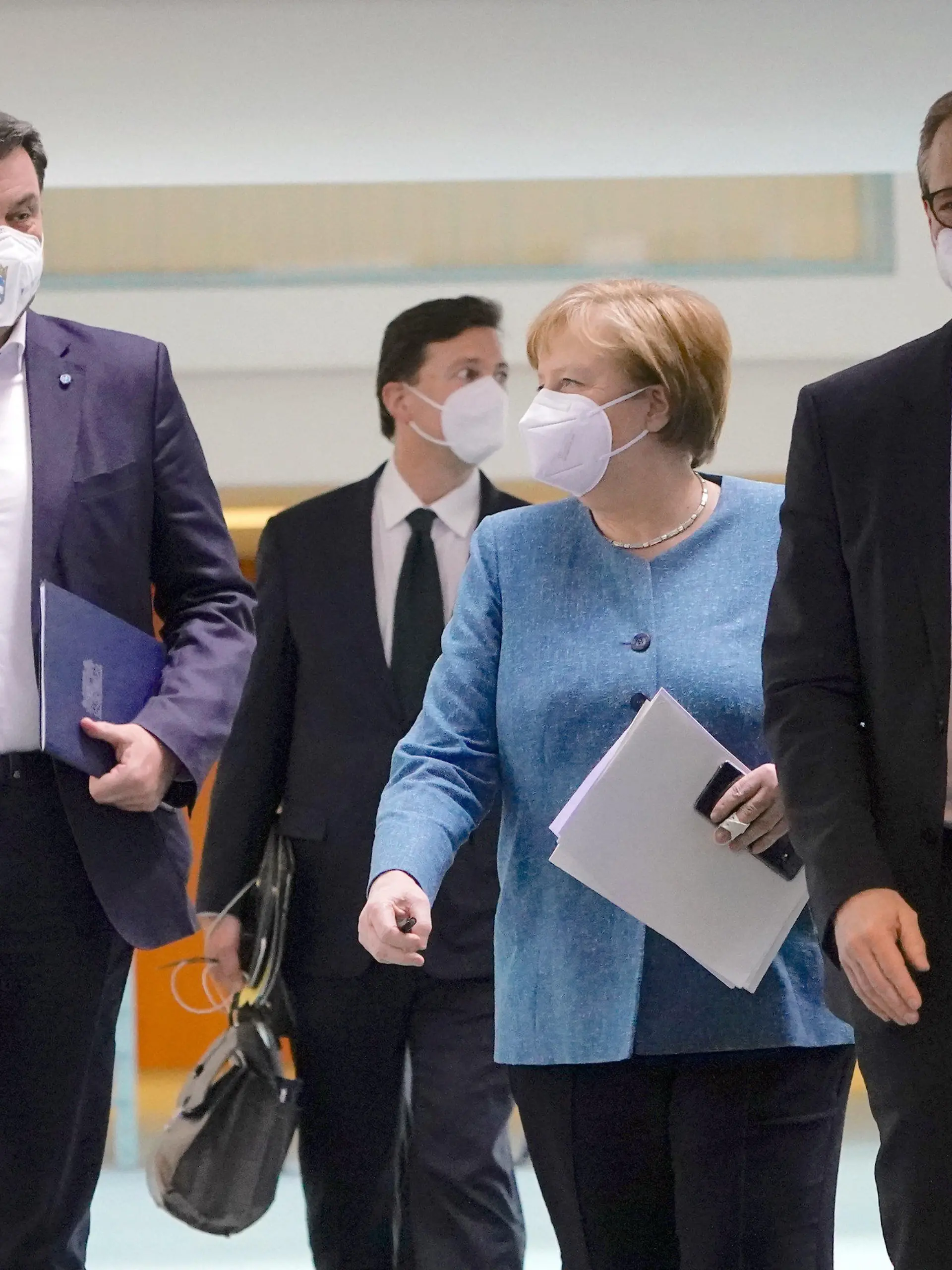 26.04.2021, Berlin: Bundeskanzlerin Angela Merkel (CDU) kommt  neben Markus Söder (CSU, l), Ministerpräsident von Bayern und CSU-Vorsitzender, und Michael Müller (r, SPD), Regierender Bürgermeister von Berlin, zu der Pressekonferenz nach dem Impfgipfel im Kanzleramt. Die Bundesregierung hat mit den Länderchefs über die Impfsituation beraten. Foto: Michael Kappeler/dpa-pool/dpa +++ dpa-Bildfunk +++