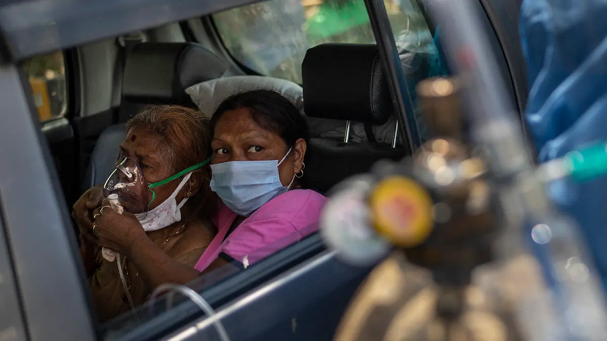24.04.2021, Indien, Neu Delhi: Eine Frau in einem Auto wird mit Sauerstoff versorgt, der von einem Gurdwara, einer Gebetsstätte der Sikhs, bereitgestellt wird. Indien mit seinen 1,3 Milliarden Einwohnern kämpft aktuell mit einer großen zweiten Corona-Welle. Foto: Altaf Qadri/AP/dpa +++ dpa-Bildfunk +++