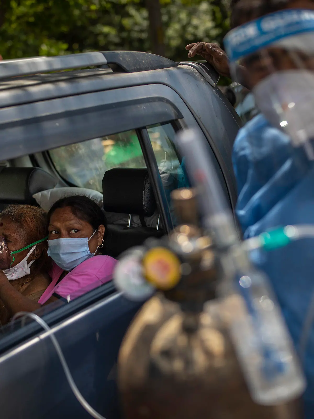 24.04.2021, Indien, Neu Delhi: Eine Frau in einem Auto wird mit Sauerstoff versorgt, der von einem Gurdwara, einer Gebetsstätte der Sikhs, bereitgestellt wird. Indien mit seinen 1,3 Milliarden Einwohnern kämpft aktuell mit einer großen zweiten Corona-Welle. Foto: Altaf Qadri/AP/dpa +++ dpa-Bildfunk +++