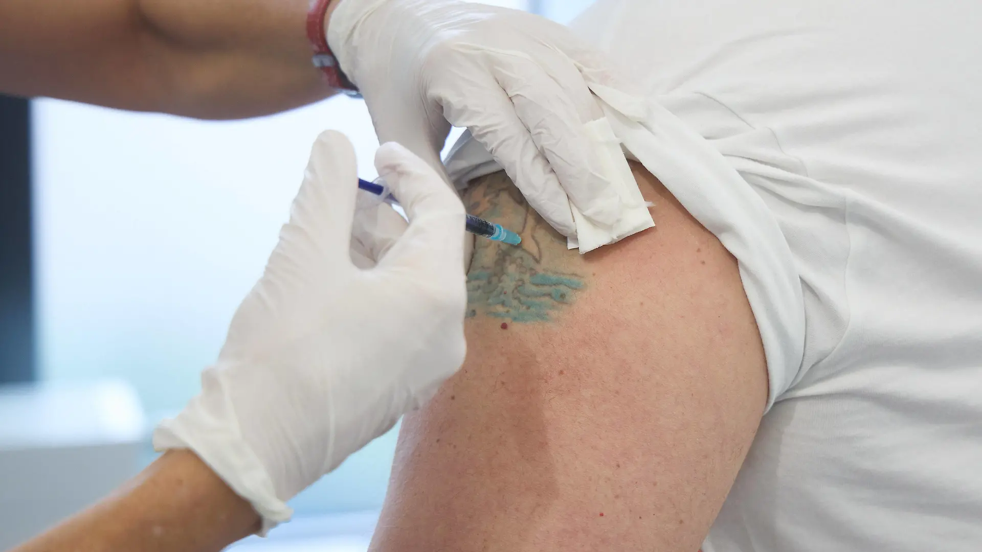 Impfung eines Mannes mittleren Alters, Impfung erfolgt in eine ungefärbte Stelle in einem Tattoo, Bayerisches Impfzentrum Augsburg, Presseführung Bayerisches Impfzentrum Augsburg, Presseführung *** Vaccination of a middle-aged man, vaccination takes place in an unstained spot in a tattoo, Bavarian Vaccination Center Augsburg, press tour Bavarian Vaccination Center Augsburg, press tour 