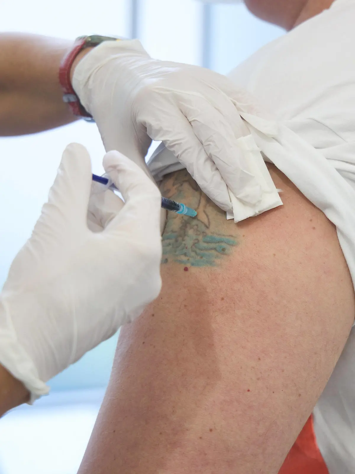 Impfung eines Mannes mittleren Alters, Impfung erfolgt in eine ungefärbte Stelle in einem Tattoo, Bayerisches Impfzentrum Augsburg, Presseführung Bayerisches Impfzentrum Augsburg, Presseführung *** Vaccination of a middle-aged man, vaccination takes place in an unstained spot in a tattoo, Bavarian Vaccination Center Augsburg, press tour Bavarian Vaccination Center Augsburg, press tour 