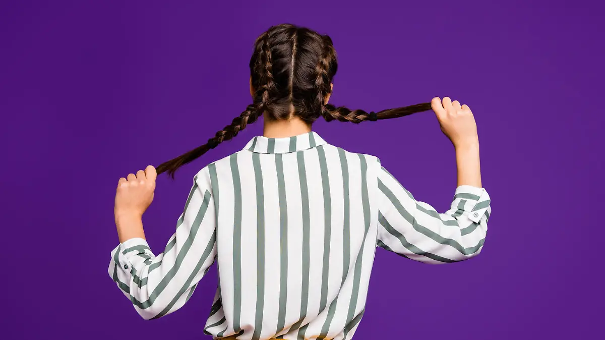 Rear behind view photo of beautiful pretty lady holding braids hands, hiding face shy person wear striped shirt yellow trousers isolated purple color background (Rear behind view photo of beautiful pretty lady holding braids hands, hiding face shy pe