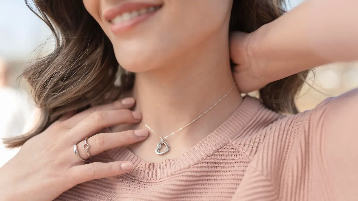 Close-up shot of a beautiful young woman wearing beautiful silver necklace and rings
