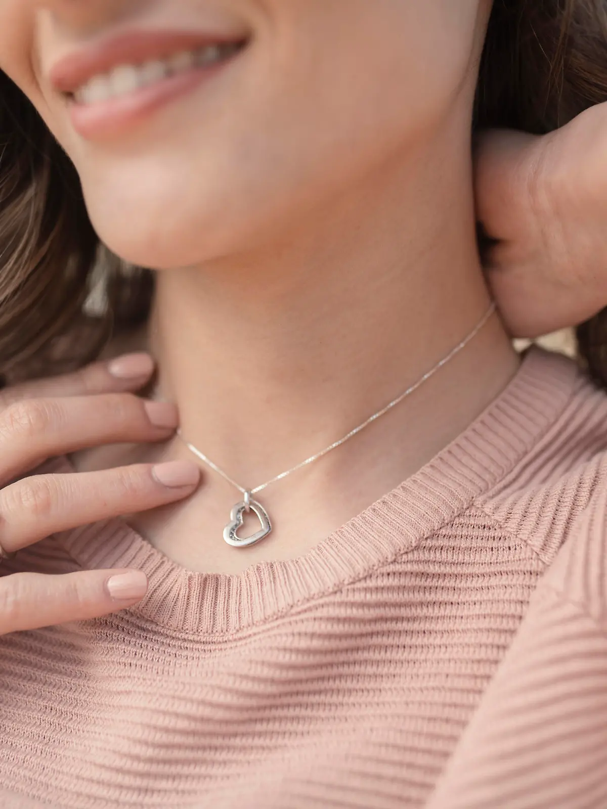 Close-up shot of a beautiful young woman wearing beautiful silver necklace and rings