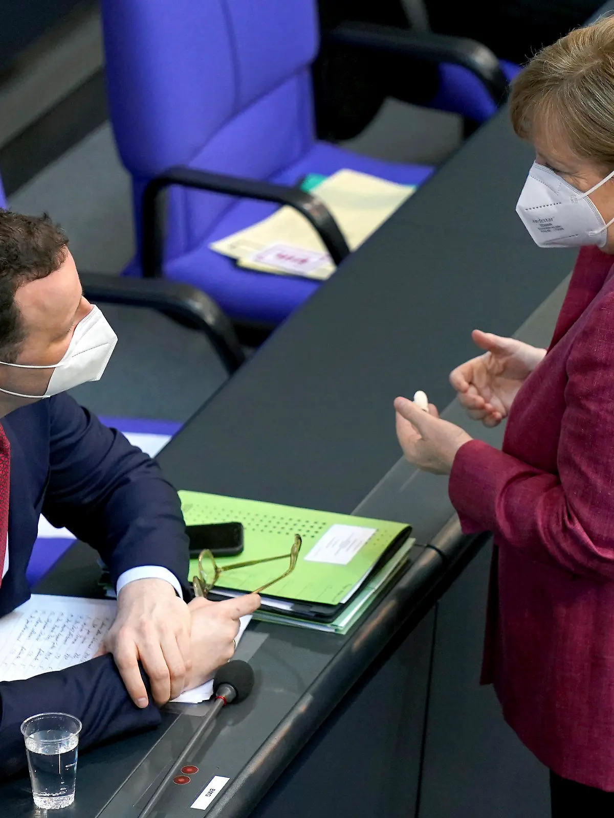 German Chancellor Angela Merkel, right, talks to German Health Minister Jens Spahn, left, during a meeting of the German federal parliament, Bundestag, at the Reichstag building in Berlin, Germany, Wednesday, April 21, 2021. (AP Photo/Michael Sohn)