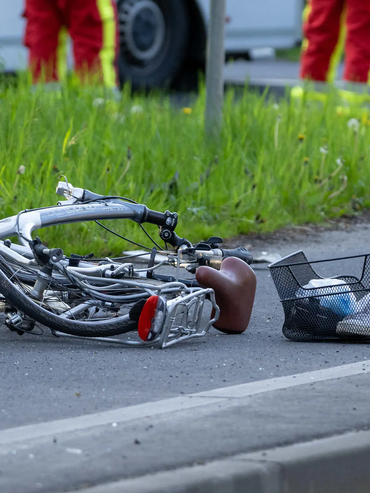 30.04.2023, Hessen, Gießen: Ein kaputtes Fahrrad liegt nach einem Unfall auf dem Gehweg. Nach Polizeiangaben vom Montag fuhr ein 30-jähriger Autofahrer Richtung Pohlheim, als es bei einer Unterführung der Autobahn 485 zum Zusammenstoß mit einer Radfahrerin kam. Die 78-Jährige wurde tödlich verletzt. Das Auto schleuderte gegen einen Baum. Die vier Insassen wurden teils schwer verletzt. Foto: Christoph Weiß/Fuldamedia/dpa +++ dpa-Bildfunk +++