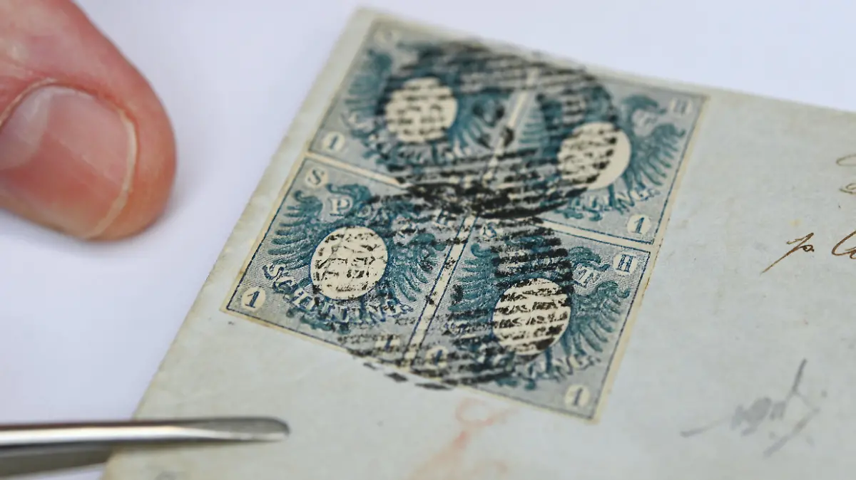 31.03.2021, Hessen, Wiesbaden: Im Auktionshaus Heinrich Köhler wird ein Viererblock einer 1 Schilling-Wappenausgabe in blau von 1850 auf kleinem Briefkuvert gezeigt. Die sogenannten «Rebellenmarken» aus Schleswig-Holstein gehören zu den seltenen Briefmarken aus den Jahren 1850/51, die am 24. April in Wiesbaden versteigert werden. Das Startgebot für die «Rebellenmarken» liegt bei 40.000 Euro. Aufgrund ihrer besonderen Geschichte gehörten die Stücke zu den exklusivsten klassischen deutschen Markenausgaben des 19. Jahrhunderts. Foto: Arne Dedert/dpa +++ dpa-Bildfunk +++