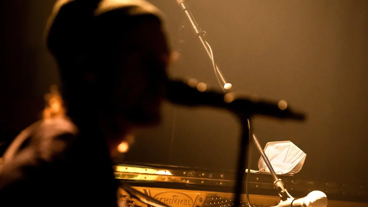 04.02.2021, Bremen: Eine Schutzmaske liegt auf dem Klavier neben einem Musiker. Bremen geht mit dem Projekt Club100 einen besonderen Weg, um der Live-Branche in der Corona-Krise neues Leben einzuhauchen. Rund 30 Konzerte sind bis Ende Mai geplant, weitere sollen dazukommen. Je nach Corona-Lage spielen die Bands und Künstler vor oder ohne Live-Publikum. Solange Veranstaltungen mit Zuschauern verboten sind, werden die Auftritte im Veranstaltungszentrum Pier2 nur per Live-Stream gezeigt. Foto: Sina Schuldt/dpa +++ dpa-Bildfunk +++