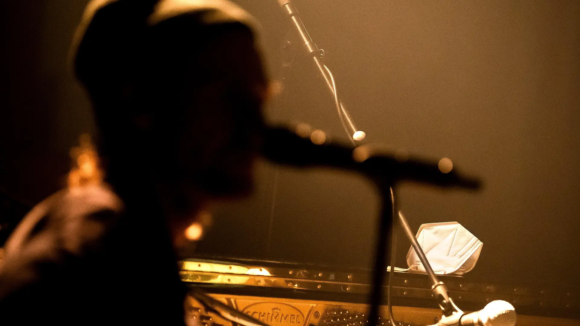 04.02.2021, Bremen: Eine Schutzmaske liegt auf dem Klavier neben einem Musiker. Bremen geht mit dem Projekt Club100 einen besonderen Weg, um der Live-Branche in der Corona-Krise neues Leben einzuhauchen. Rund 30 Konzerte sind bis Ende Mai geplant, weitere sollen dazukommen. Je nach Corona-Lage spielen die Bands und Künstler vor oder ohne Live-Publikum. Solange Veranstaltungen mit Zuschauern verboten sind, werden die Auftritte im Veranstaltungszentrum Pier2 nur per Live-Stream gezeigt. Foto: Sina Schuldt/dpa +++ dpa-Bildfunk +++
