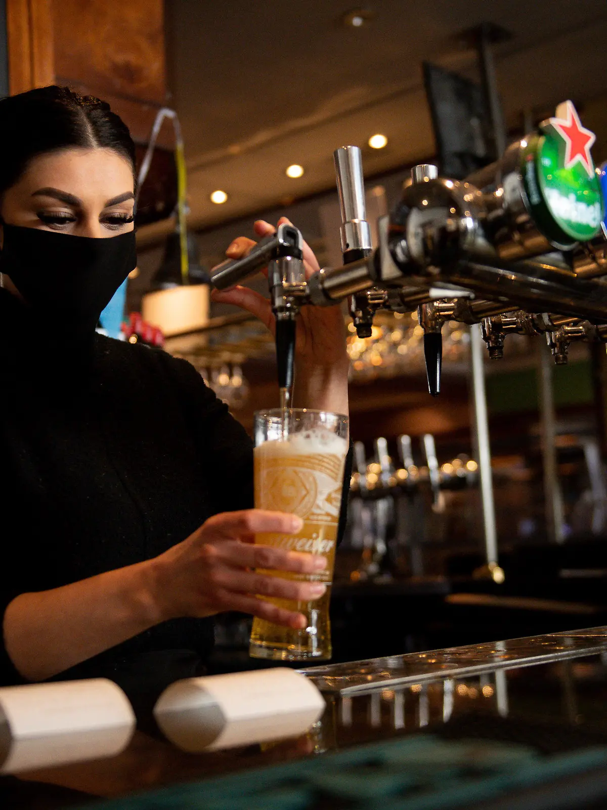 ARCHIV - 12.04.2021, Großbritannien, Birmingham: Eine Kellnerin im Pub «Figure of Eight» zapft ein Bier. Der Marktzugang für Lager-Biere, wie in Großbritannien alle untergärigen Biersorten und also auch Pilsner genannt werden, ist schwierig. Marken wie Stella Artois, Kronenbourg oder eben Heineken haben die Szene unter sich aufgeteilt. (zu dpa «Beliebt im Shop, no chance im Pub: Deutsches Bier in Großbritannien») Foto: Jacob King/PA Wire/dpa +++ dpa-Bildfunk +++