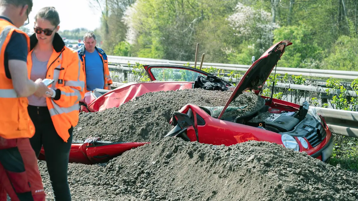 Ein völlig verbeulter VW Lupo, begraben unter Schotter, auf der B3 bei Bad Vilbel.