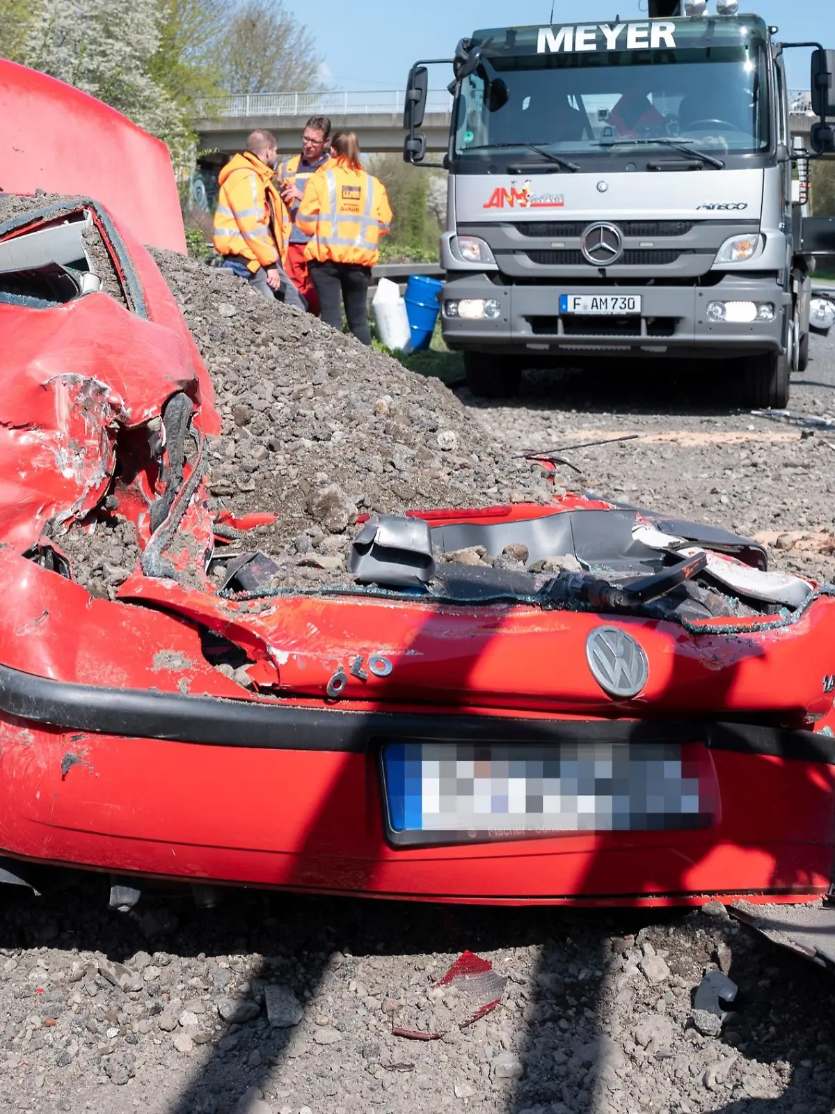 Nachdem ein Lkw seine aus Schotter bestehende Ladung verloren hatte, steht ein völlig zerstörter Pkw auf der B3.
