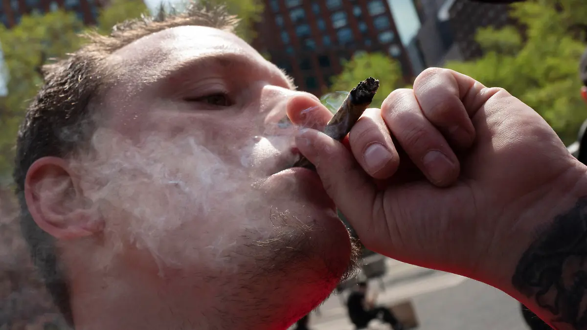 20.04.2021, USA, New York: Michael Keren raucht bei der «Joints for Jabs»-Veranstaltung (etwa "Joints für eine Injektion") einen Joint. Personen, die einen Corona-Impfnachweis vorzeigten, erhielten einen kostenlosen Joint. Der Konsum von Marihuana ist im Bundesstaat New York zuvor legalisiert worden. Foto: Mark Lennihan/AP/dpa +++ dpa-Bildfunk +++