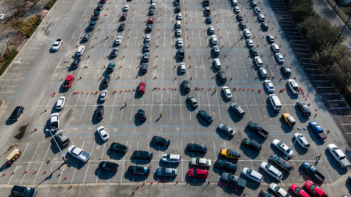 ARCHIV - 24.02.2021, USA, Houston: Autos stehen auf einem Parkplatz am NRG Park in einer Schlange, während die Fahrer darauf warten, gegen das Coronavirus geimpft zu werden. Die große Impf-Einrichtung in Harris County wird staatlich gefördert. (Illsutration zu: "Rund 3,5 Millionen Impfungen an einem Tag - USA stellen Rekord auf") Foto: Mark Mulligan/Houston Chronicle/AP/dpa - ACHTUNG: Nur zur redaktionellen Verwendung und nur mit vollständiger Nennung des vorstehenden Credits +++ dpa-Bildfunk +++