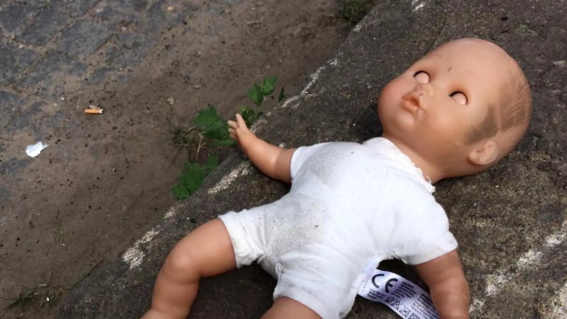 Eine Puppe liegt am Straßenrand