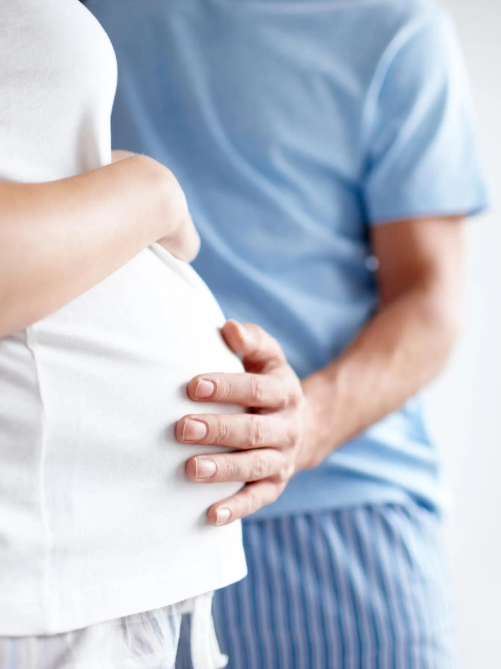 Mann hält Hand auf Schwangerschaftsbauch