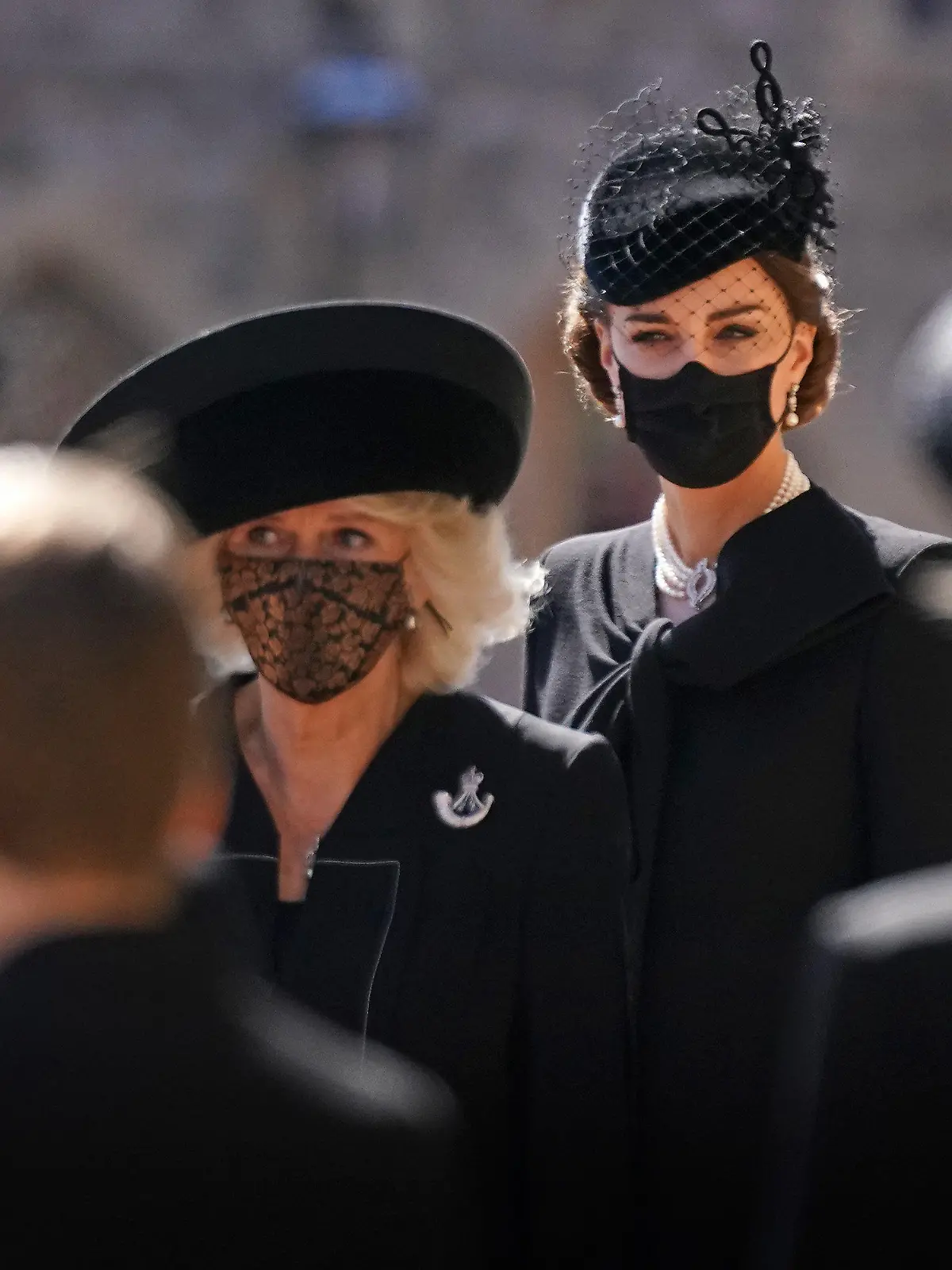17.04.2021, Großbritannien, Windsor: Camilla, Herzogin von Cornwall (3.v.l.) und Kate, Herzogin von Cambridge (2.v.r.), stehen vor der St.-Georgs-Kapelle auf Schloss Windsor. Die Trauerfeier und Beisetzung von Queen-Ehemann Prinz Philip, Herzog von Edinburg, finden auf Schloss Windsor statt. Prinz Philip war am 9. April im Alter von 99 Jahren gestorben. Foto: Victoria Jones/PA Wire/dpa +++ dpa-Bildfunk +++