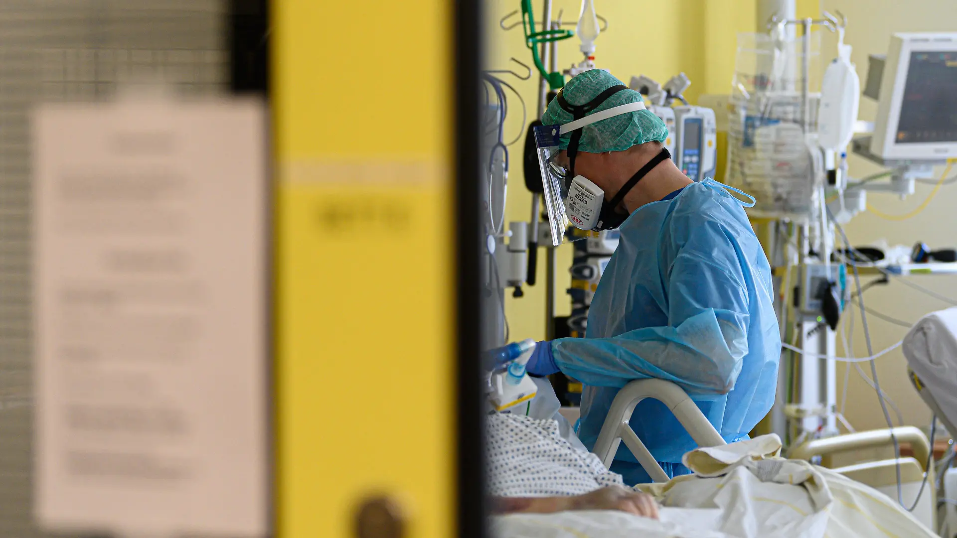 18.01.2021, Sachsen, Dresden: Ein Intensivpfleger ist auf der Covid-19 Intensivstation (ITS) im Städtischen Klinikum Dresden mit der Versorgung von Corona-Patienten beschäftigt. Am Vormittag besuchte der sächsische Ministerpräsident das Klinikum um einen Austausch mit Klinikführung und Mitarbeitern aus Medizin und Pflege in Bezug auf die Auswirkungen der Corona-Pandemie im Klinikalltag zu führen. Foto: Robert Michael/dpa-Zentralbild/dpa +++ dpa-Bildfunk +++