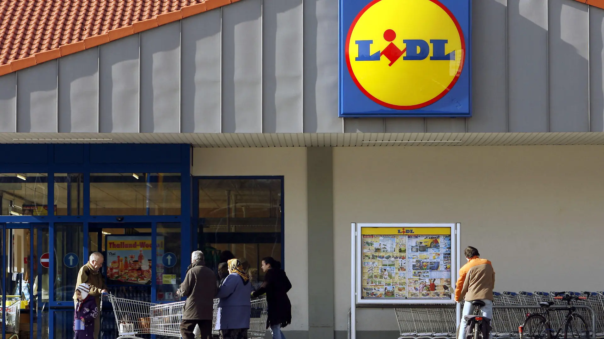 ARCHIV - ILLUSTRATION - Leute schieben am 22.02.2007 vor einem Lidl-Markt in Ludwigsburg ihre Einkaufswagen und ein Kunde schaut sich ein Werbeplakat an. Foto: Marijan Murat/ dpa (zu dpa: "Discounter Lidl erpresst - Polizei nimmt Verdächtige fest") +++(c) dpa - Bildfunk+++
