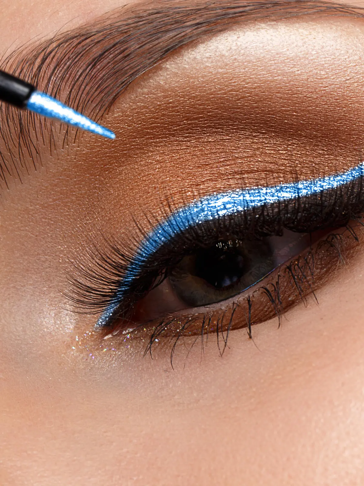 Frau, die blauen Eyeliner aufträgt.
